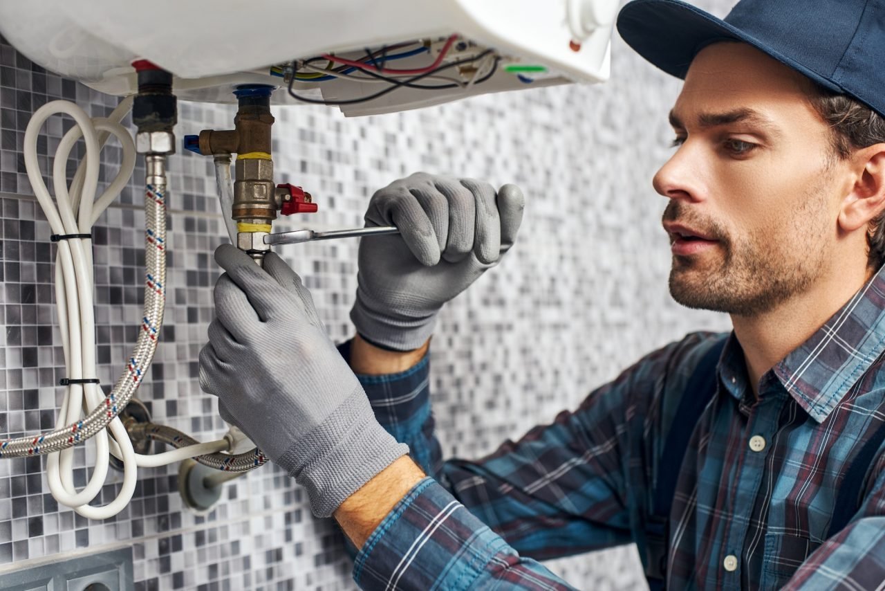 Plombier installant une chaudière électrique dans une salle de bain